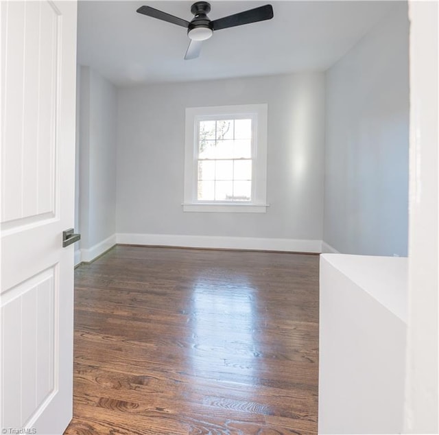 spare room with dark hardwood / wood-style floors and ceiling fan