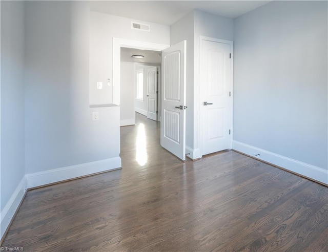 spare room featuring dark wood-type flooring