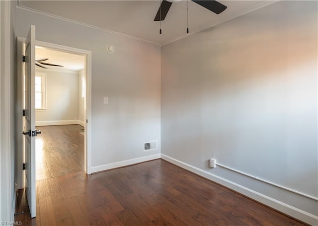 empty room with ceiling fan, dark wood-type flooring, and ornamental molding