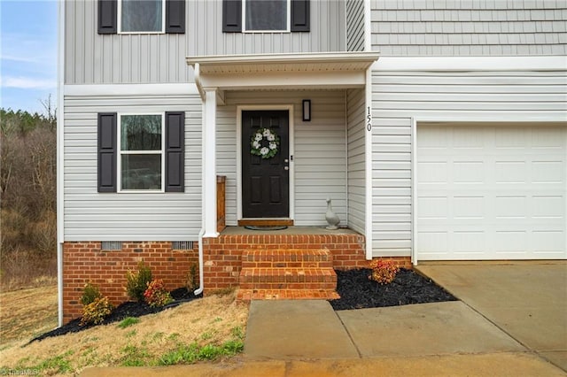 view of exterior entry with crawl space, an attached garage, and board and batten siding