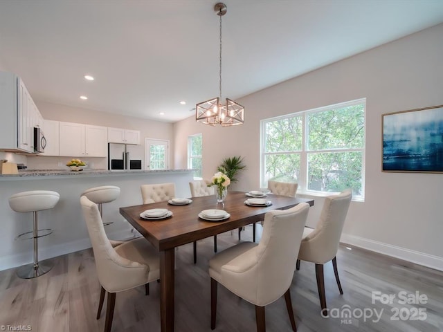 dining space featuring hardwood / wood-style floors and a notable chandelier