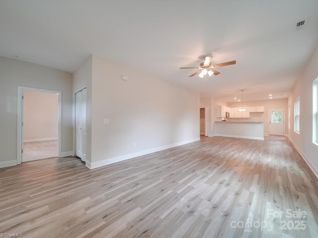 unfurnished living room with ceiling fan and light hardwood / wood-style floors