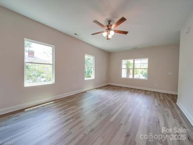 empty room with ceiling fan and light hardwood / wood-style flooring