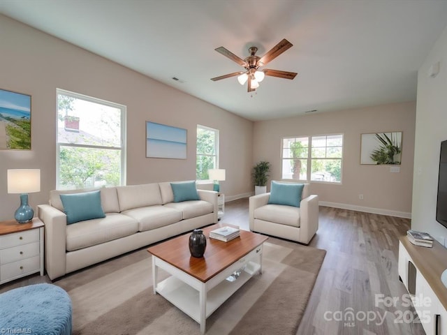 living room with ceiling fan and light hardwood / wood-style flooring