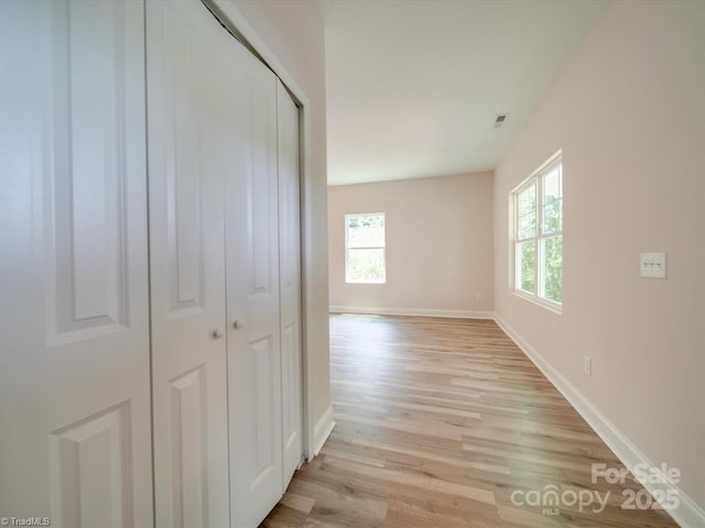 corridor featuring light wood-type flooring and plenty of natural light