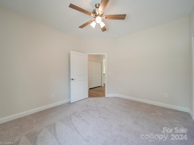 unfurnished room with light colored carpet and ceiling fan