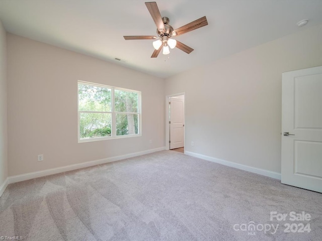 empty room featuring ceiling fan and light colored carpet