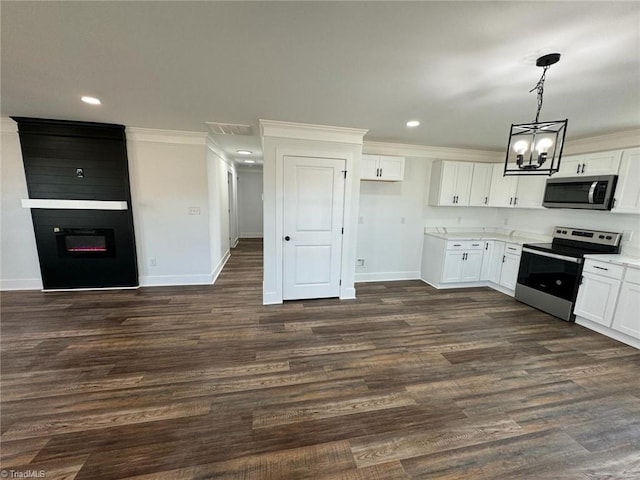 kitchen featuring a fireplace, white cabinets, hanging light fixtures, and appliances with stainless steel finishes