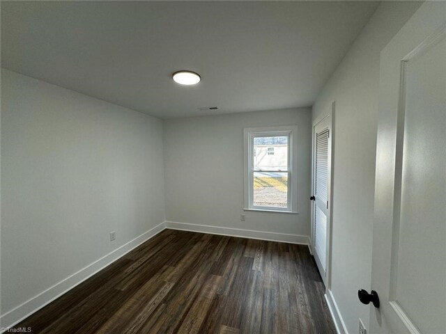 spare room with dark wood-type flooring