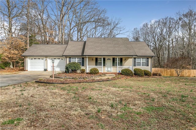 view of front of property with a garage, driveway, a porch, fence, and a front lawn