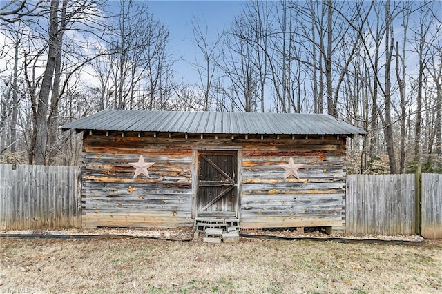 view of outbuilding featuring fence and an outdoor structure