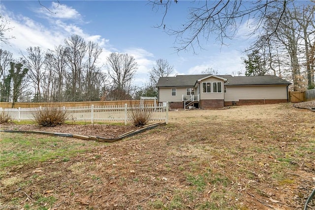 rear view of property with a fenced backyard