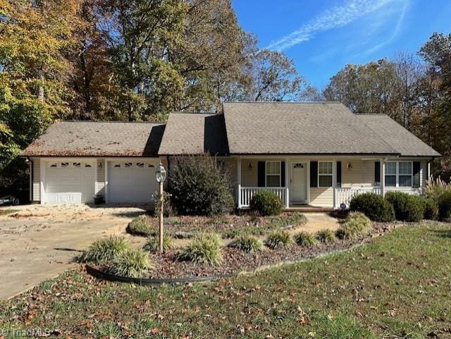 ranch-style home with a garage, covered porch, and driveway