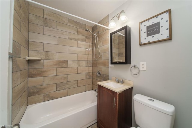 full bathroom featuring tiled shower / bath, vanity, and toilet