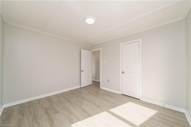 unfurnished room with crown molding and light hardwood / wood-style flooring