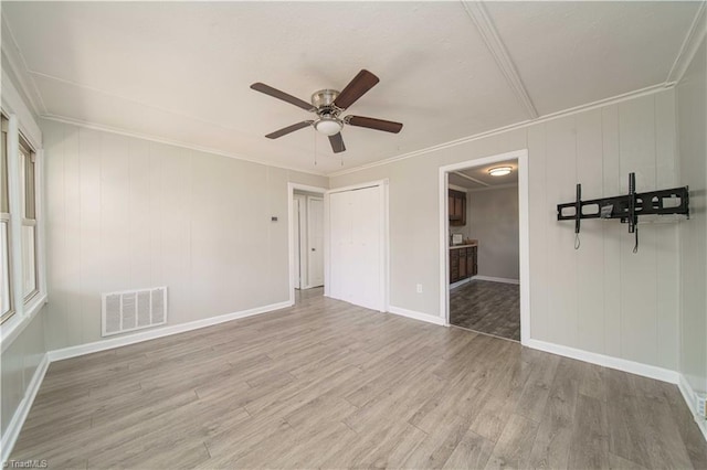 unfurnished room featuring light hardwood / wood-style flooring, ornamental molding, and ceiling fan