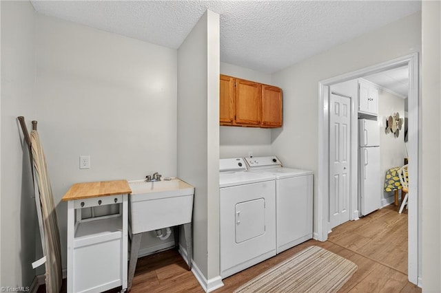 209 Brewer Cir, East Bend, NC 27018 - washroom featuring cabinet space, independent washer and dryer, light wood-type flooring, and a textured ceiling
