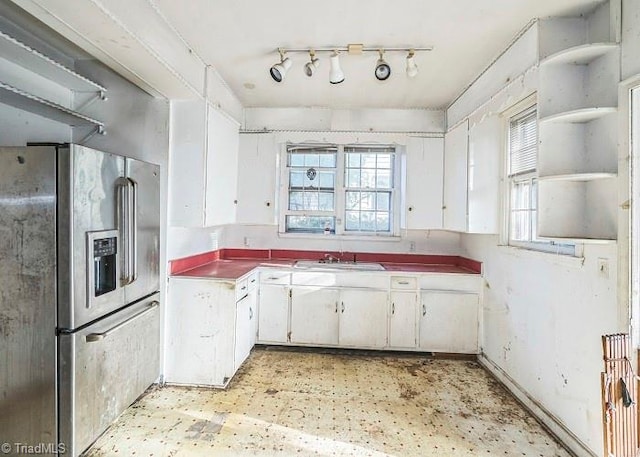 kitchen with stainless steel refrigerator with ice dispenser, white cabinetry, plenty of natural light, and sink