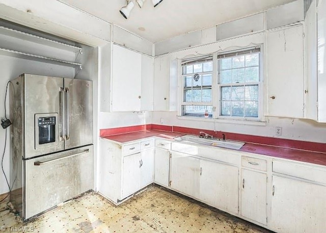 kitchen featuring white cabinetry, sink, and stainless steel refrigerator with ice dispenser