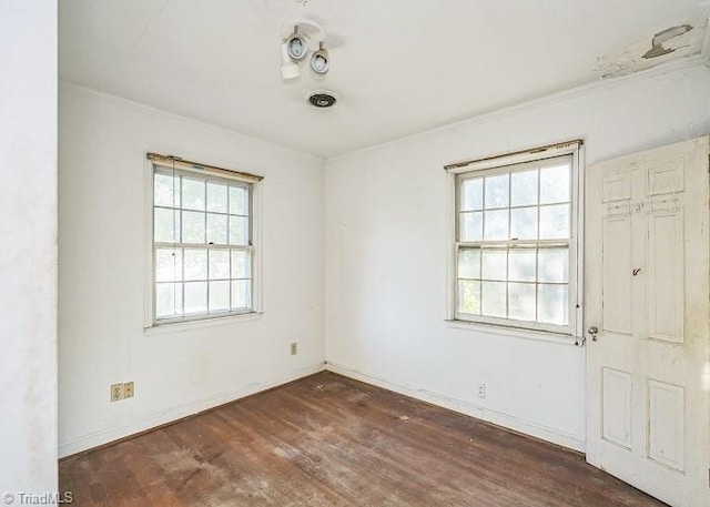 unfurnished room with ornamental molding and dark wood-type flooring