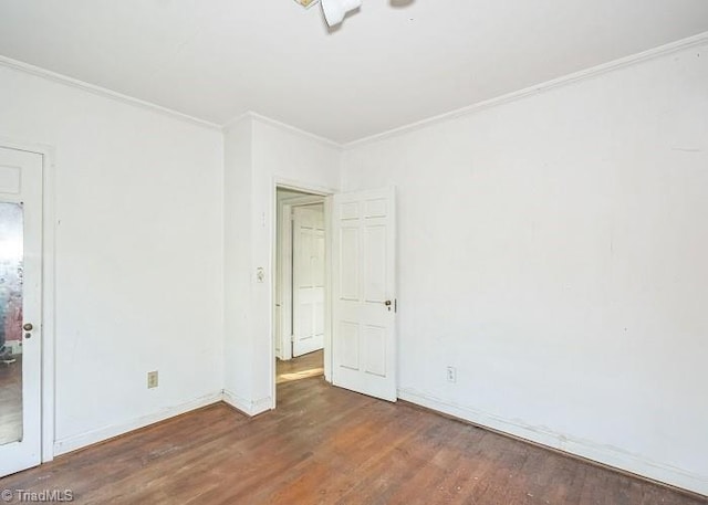 empty room featuring crown molding and dark wood-type flooring