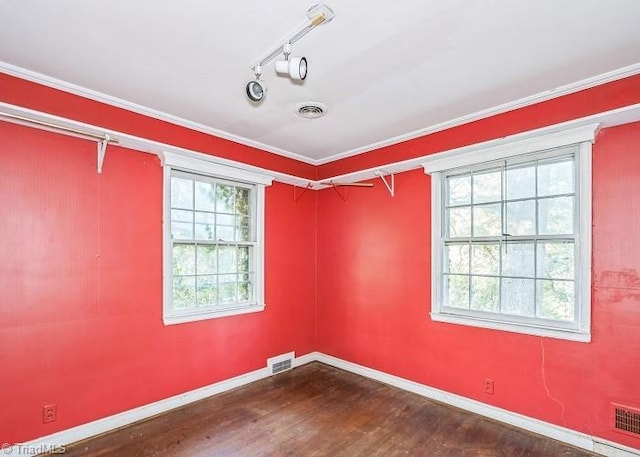 spare room with crown molding, dark hardwood / wood-style flooring, and track lighting