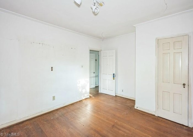 empty room with crown molding and hardwood / wood-style floors