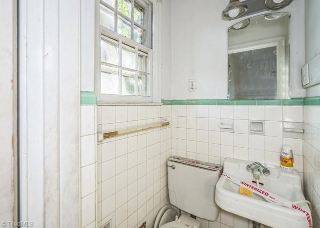 bathroom with sink and tile walls