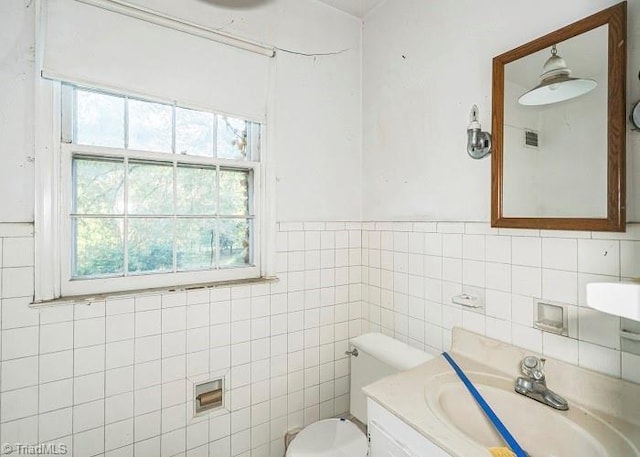 bathroom featuring vanity, toilet, and tile walls