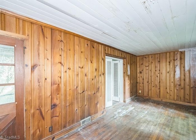 empty room with wood walls and wood-type flooring