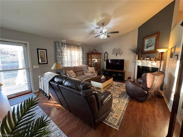 living room with dark wood-type flooring, ceiling fan, and vaulted ceiling