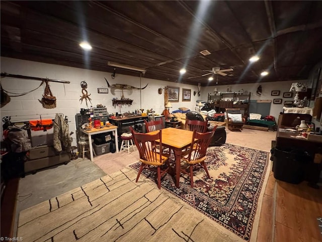 dining space featuring concrete flooring, a workshop area, and ceiling fan