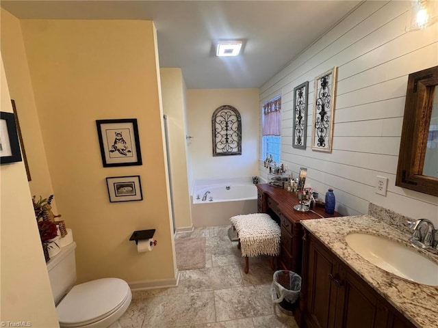 bathroom featuring toilet, vanity, a bath, and wood walls