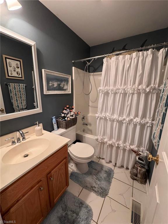 full bathroom with shower / tub combo, vanity, and toilet