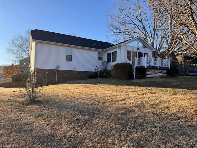 back of property with a yard and a deck