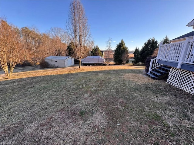 view of yard with a wooden deck and a shed