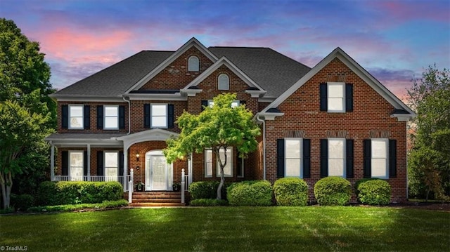 view of front of home with brick siding and a front lawn