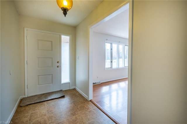 foyer entrance featuring baseboards and visible vents