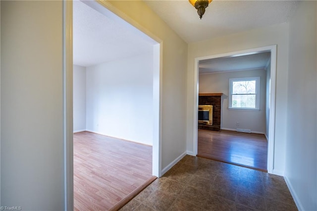 corridor with dark wood-style floors, a textured ceiling, and baseboards