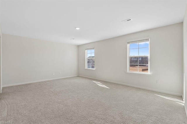 unfurnished room featuring carpet, visible vents, and baseboards