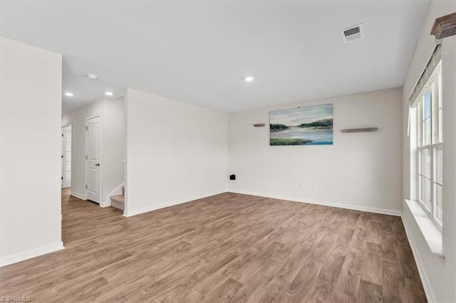 empty room with light wood-type flooring, visible vents, baseboards, and recessed lighting