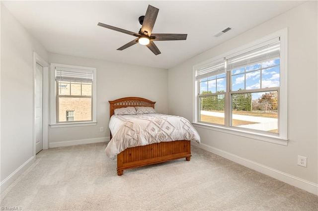 carpeted bedroom featuring ceiling fan and multiple windows