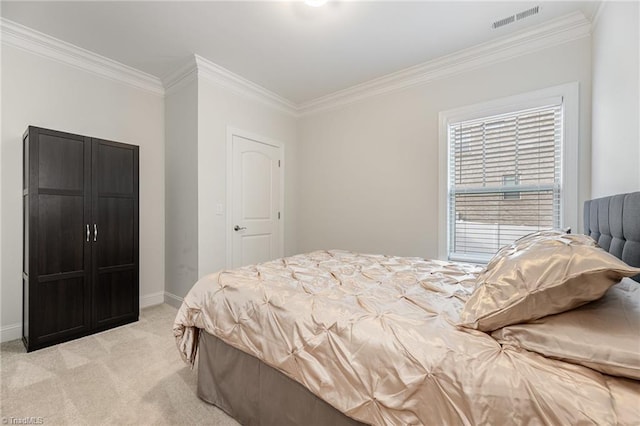 bedroom with ornamental molding and light colored carpet