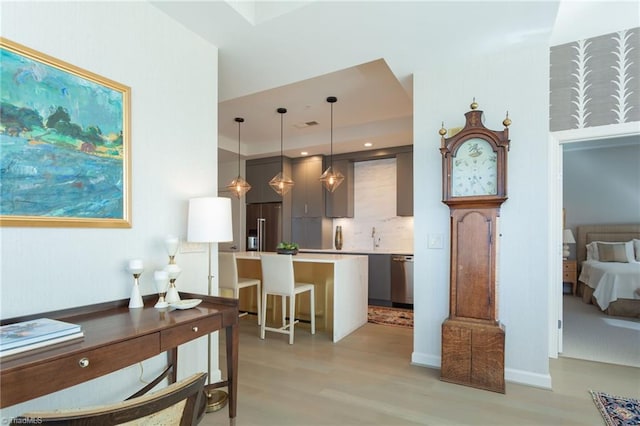 kitchen featuring a breakfast bar, built in refrigerator, hanging light fixtures, dishwasher, and a kitchen island