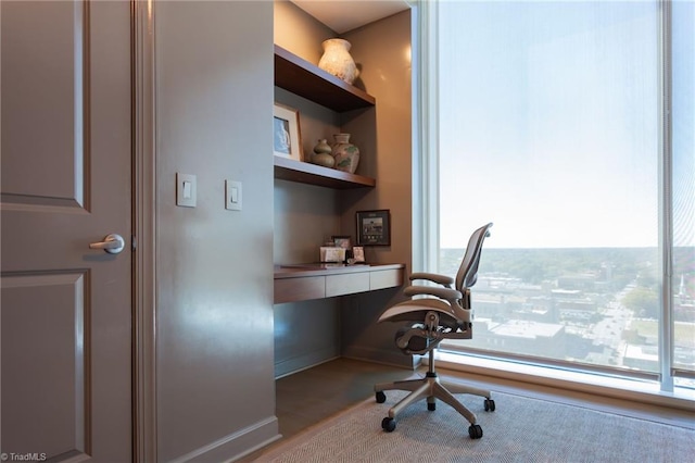 office area featuring built in shelves, built in desk, and a healthy amount of sunlight