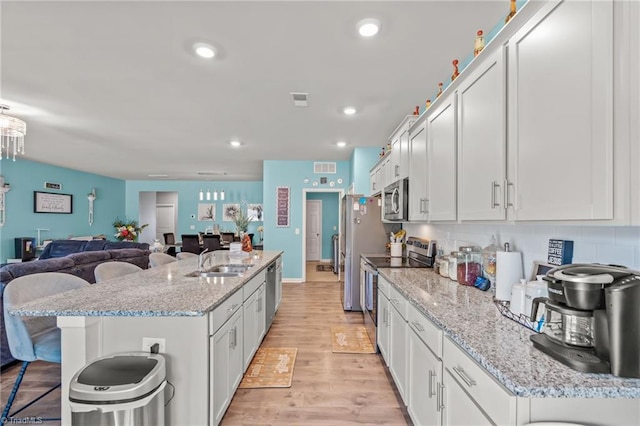 kitchen with stainless steel appliances, a sink, and white cabinets