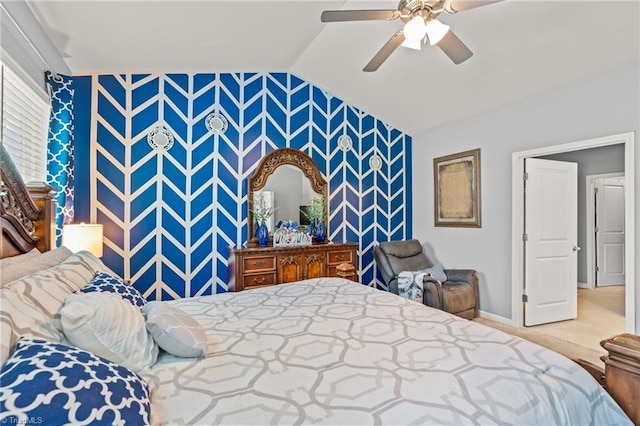 bedroom featuring lofted ceiling, ceiling fan, an accent wall, baseboards, and wallpapered walls