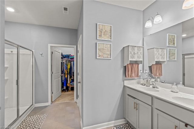 full bath with a sink, a spacious closet, and a shower stall