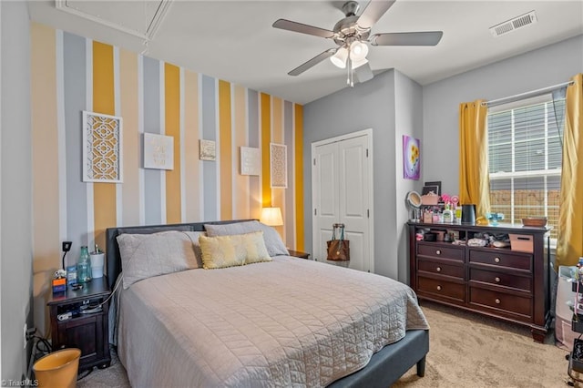 bedroom with light carpet, visible vents, a closet, attic access, and wallpapered walls