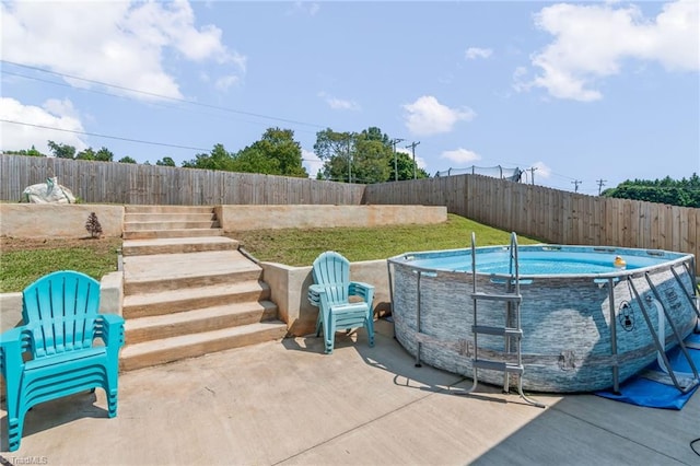 view of pool with a fenced backyard, a fenced in pool, and a patio